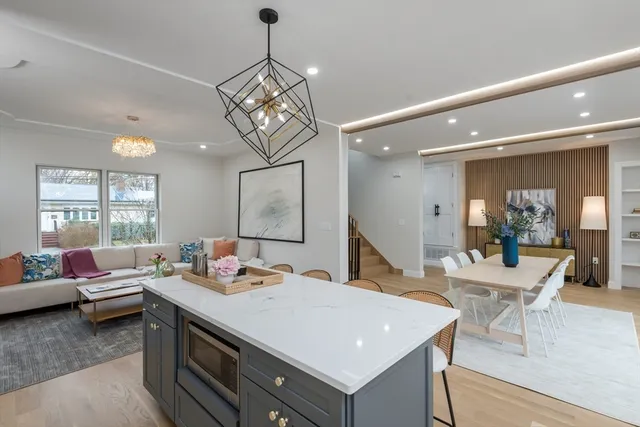 a view of a dining room and livingroom with furniture wooden floor a chandelier