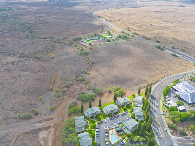 a view of a dry yard with wooden fence
