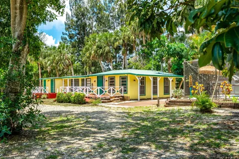 a view of a house with backyard sitting area and garden