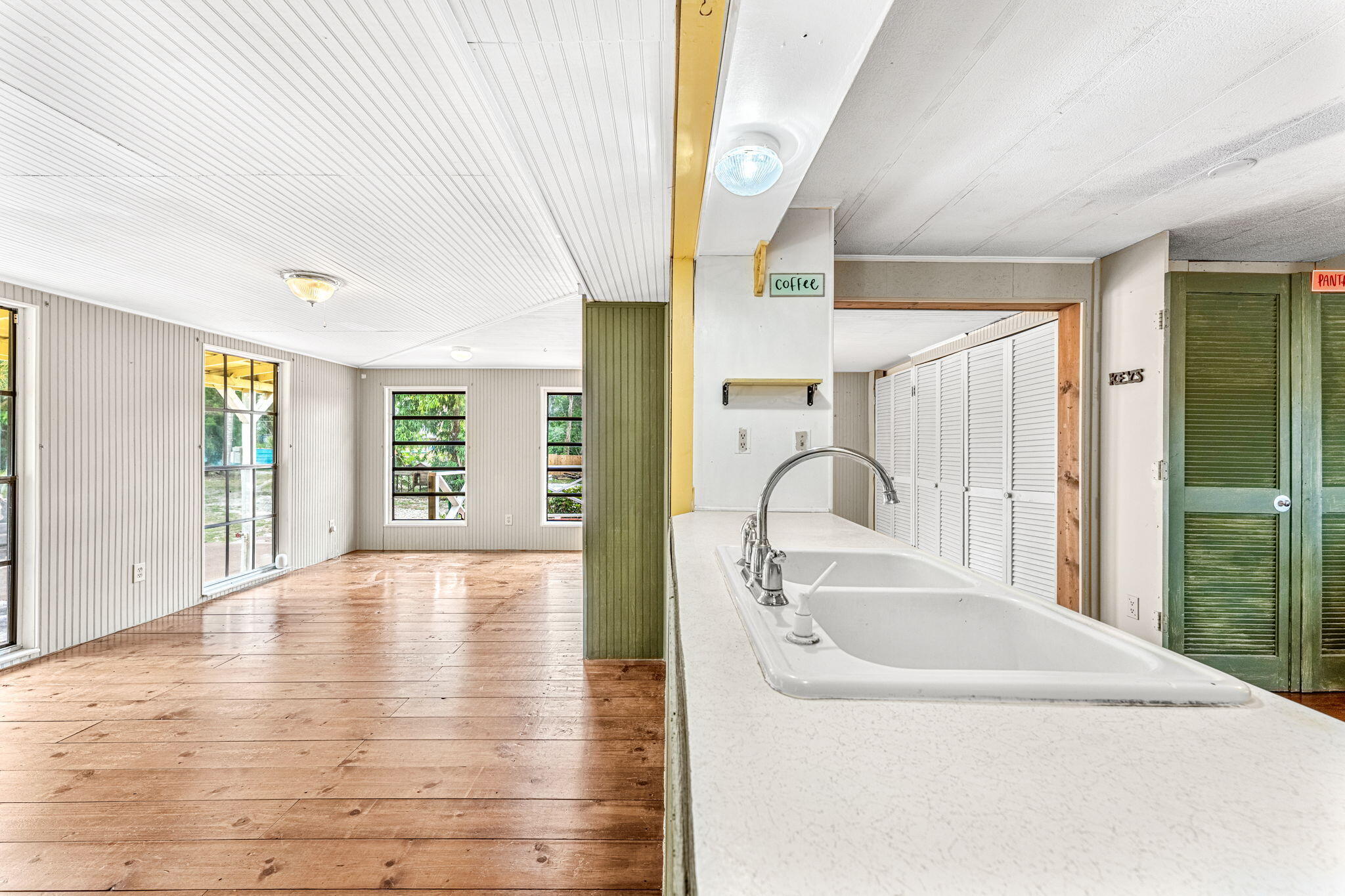 7680 Highway 1 Micco, FL 32976 - Photo 55 of 84 a view of a kitchen with a sink dishwasher cabinets with wooden floor next to a window