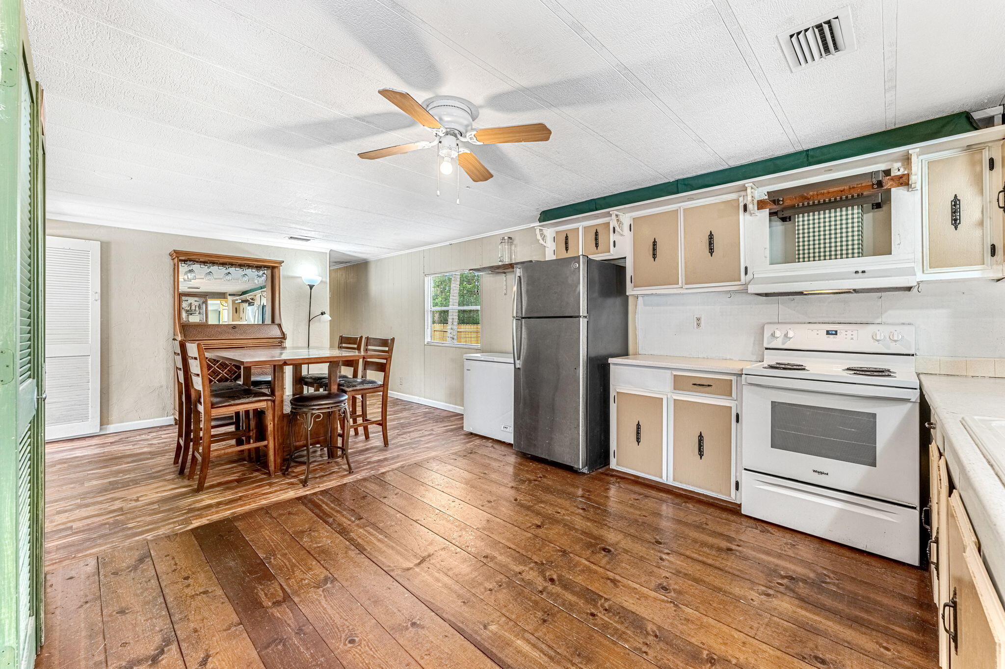 7680 Highway 1 Micco, FL 32976 - Photo 60 of 84 a kitchen with stainless steel appliances a stove a refrigerator cabinets and a dining table