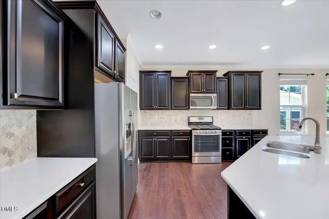 a kitchen with stainless steel appliances granite countertop a sink stove and refrigerator