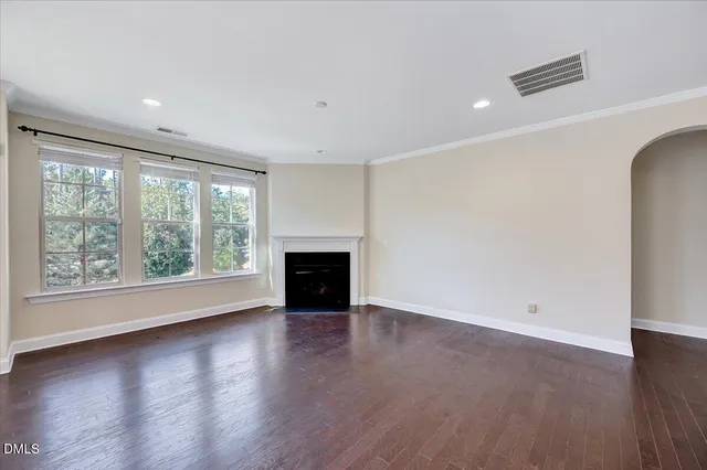 an empty room with wooden floor and a fireplace