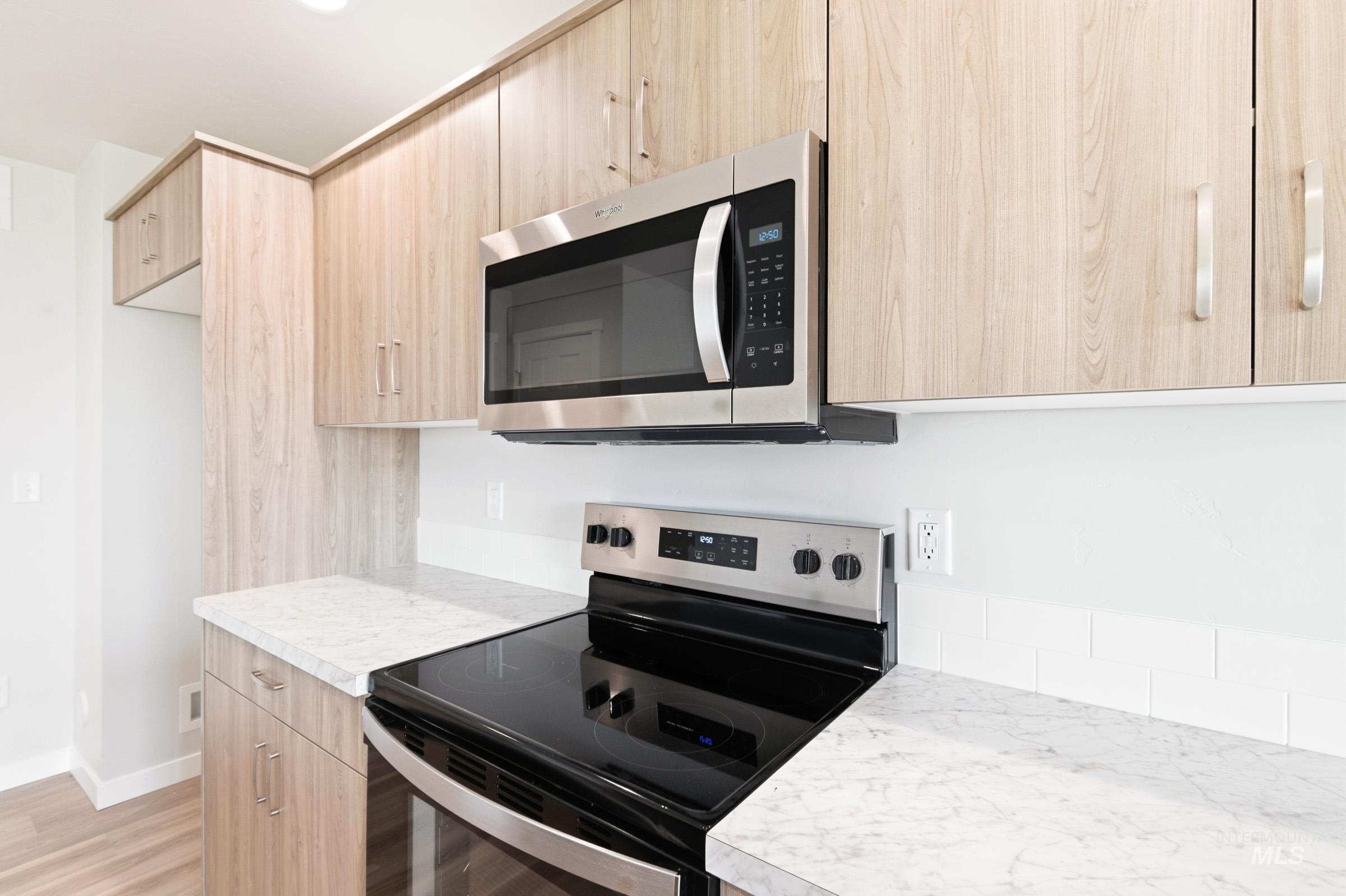 2446 West Fallon Loop Nampa, ID 83651 - Photo 6 of 19 Kitchen featuring stainless steel appliances, light wood finish cabinets, light countertops, light wood-style flooring, and modern cabinets