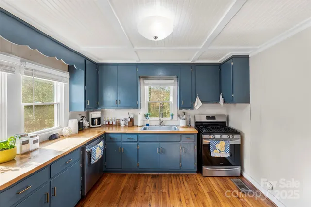 a kitchen with stainless steel appliances sink a stove and cabinets