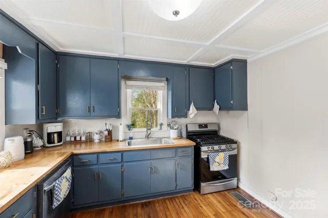 a kitchen with sink a stove and cabinets