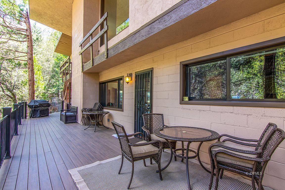 55596 Encino Road Idyllwild, CA 92549 - Photo 21 of 74 a view of a patio with table and chairs with wooden floor and fence