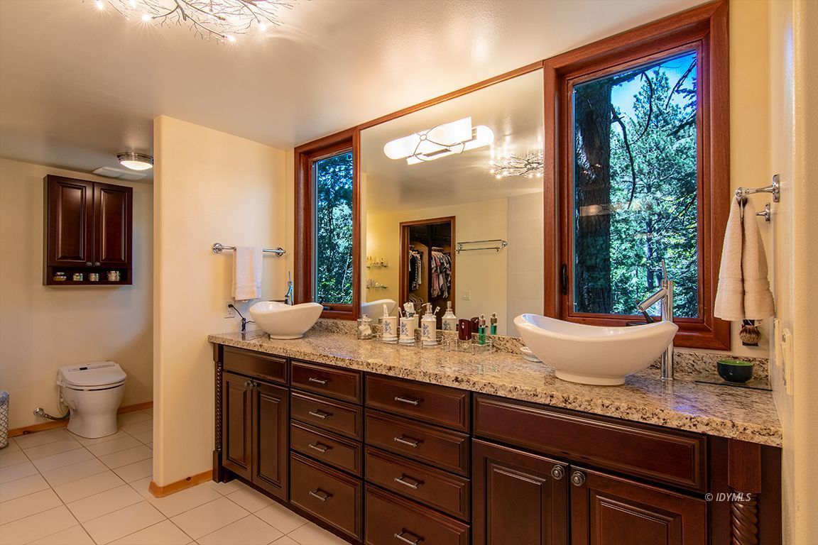 55596 Encino Road Idyllwild, CA 92549 - Photo 49 of 74 a bathroom with a granite countertop sink a toilet and mirror
