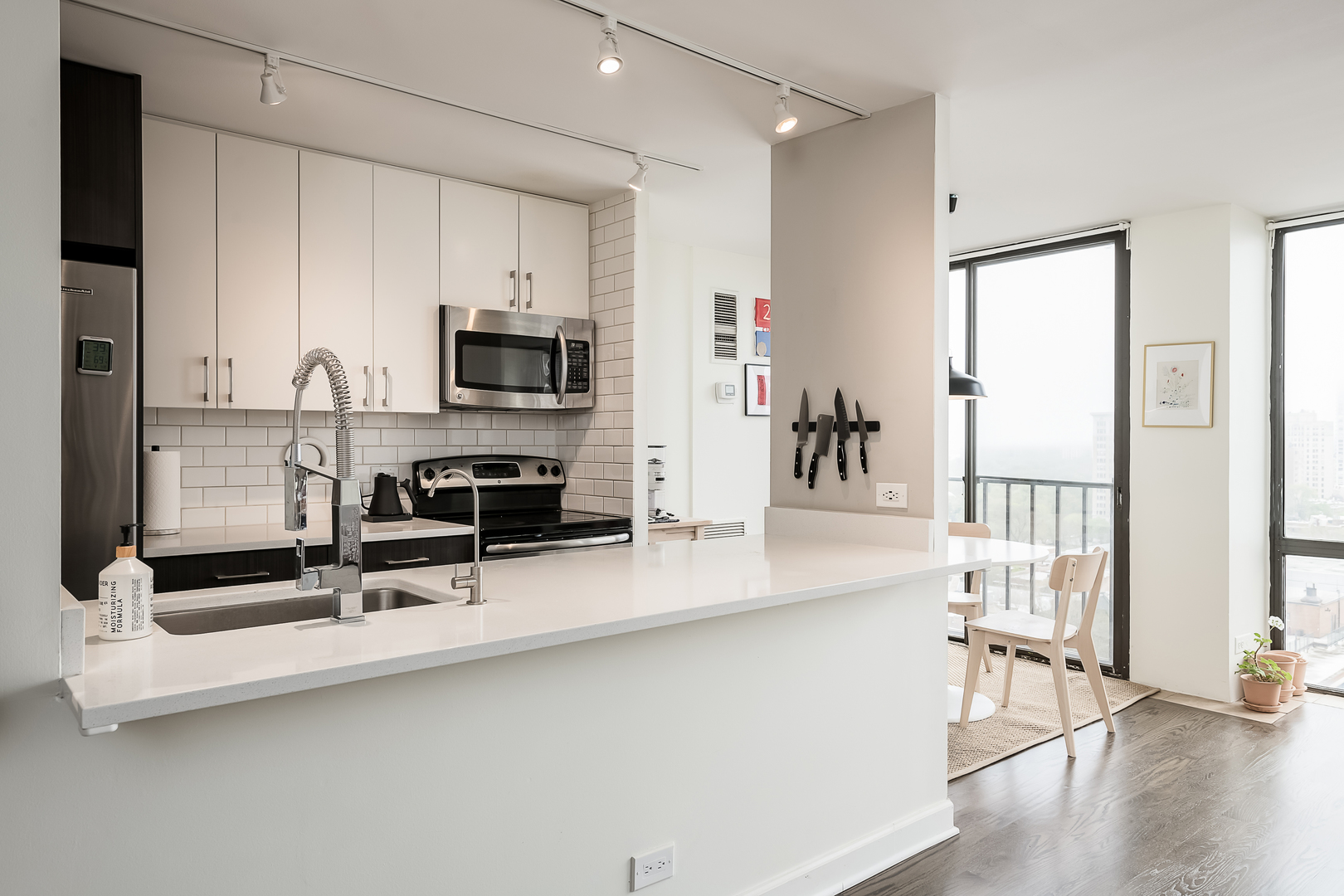 345 West Fullerton Parkway, Unit 1706 Chicago, IL 60614 - Photo 10 of 26 a kitchen with stainless steel appliances a stove top oven a sink a dining table and chairs