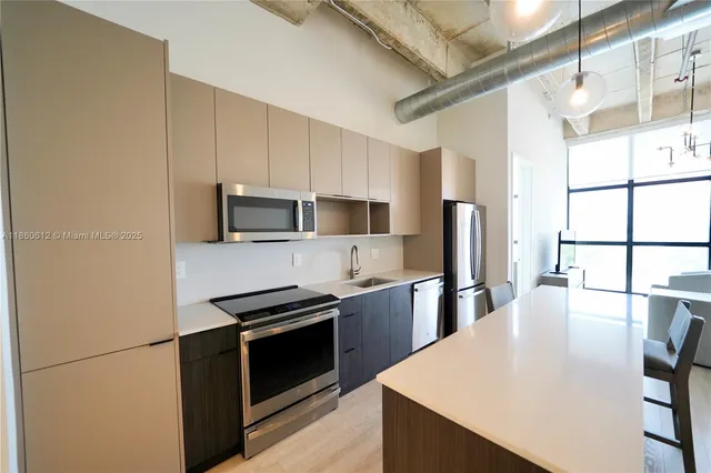 a kitchen with stainless steel appliances a stove microwave and refrigerator