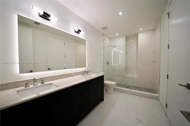 a bathroom with a double vanity sink mirror double and shower