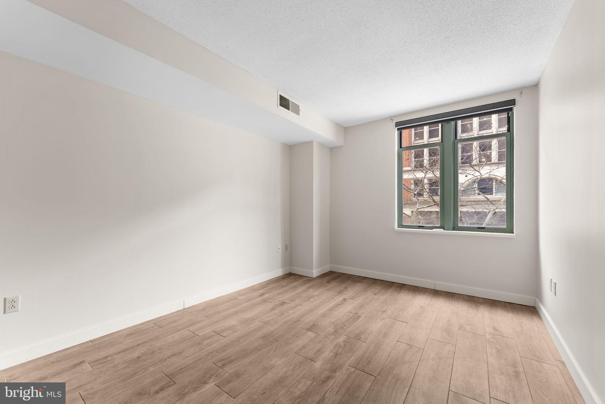1150 K Street Northwest, Unit 306 Washington, DC 20005 - Photo 15 of 23 an empty room with wooden floor and windows