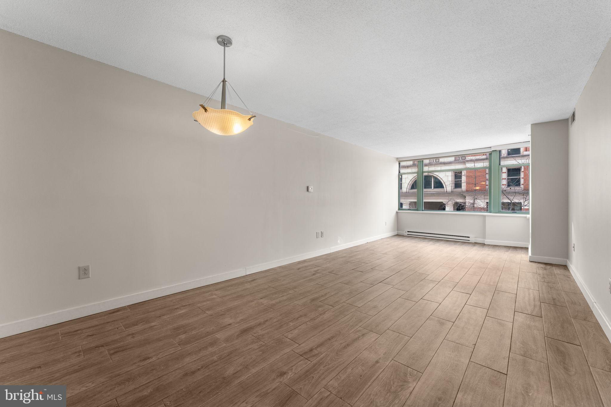 1150 K Street Northwest, Unit 306 Washington, DC 20005 - Photo 8 of 23 a view of a room with wooden floor and window