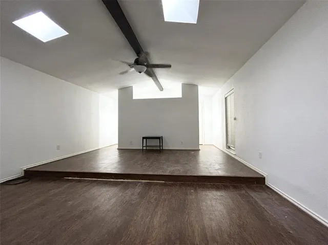 an empty room with wooden floor and staircase