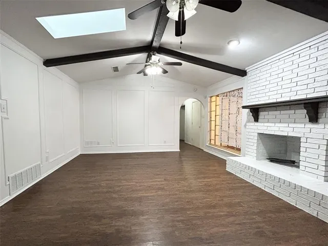 a view of an empty room with a fireplace and a window