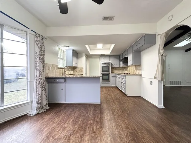 a kitchen with stainless steel appliances kitchen island wooden cabinets and granite counter tops