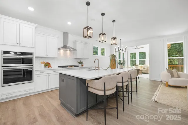 a kitchen with a dining table chairs and white cabinets