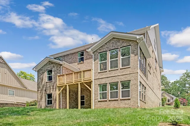 a view of a blue white house with windows and a yard