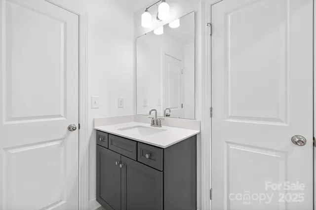a bathroom with a sink a light fixture and a mirror