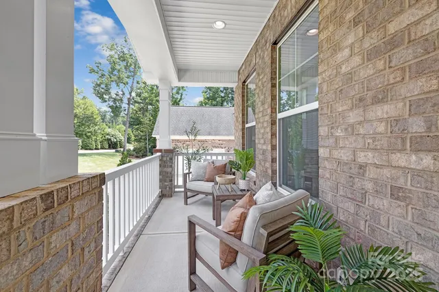 a balcony with chairs and with a potted plant