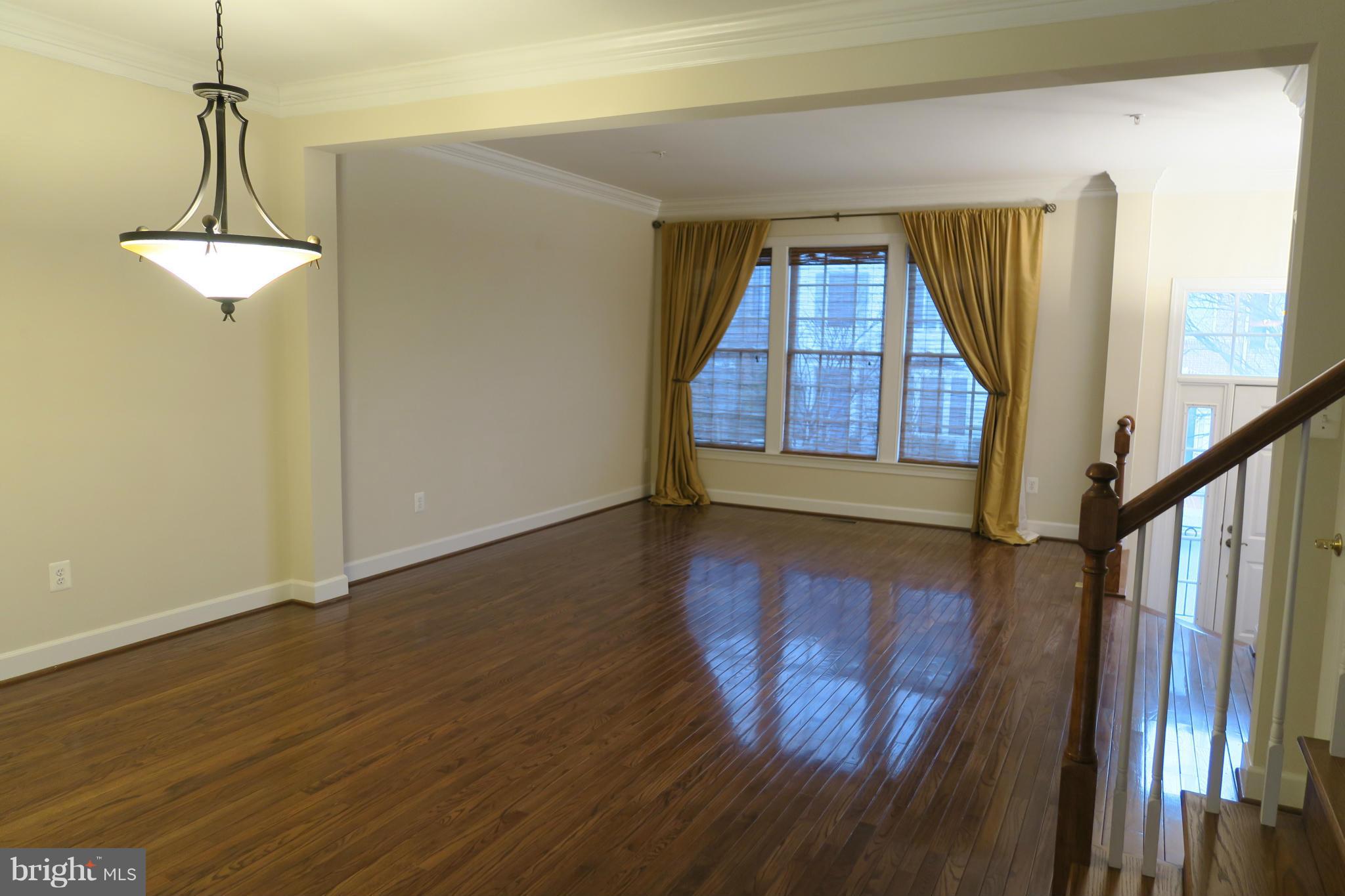 725 Ridgemont Avenue Rockville, MD 20850 - Photo 2 of 17 a view of a hallway with wooden floor and stairs