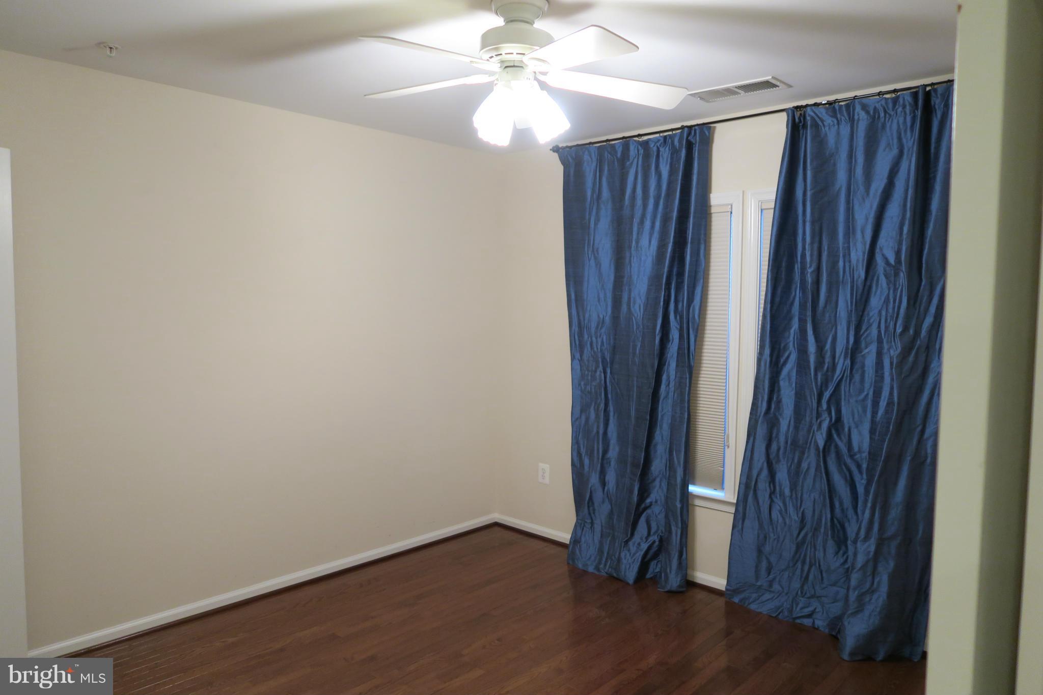 725 Ridgemont Avenue Rockville, MD 20850 - Photo 8 of 17 an empty room with wooden floor and fan