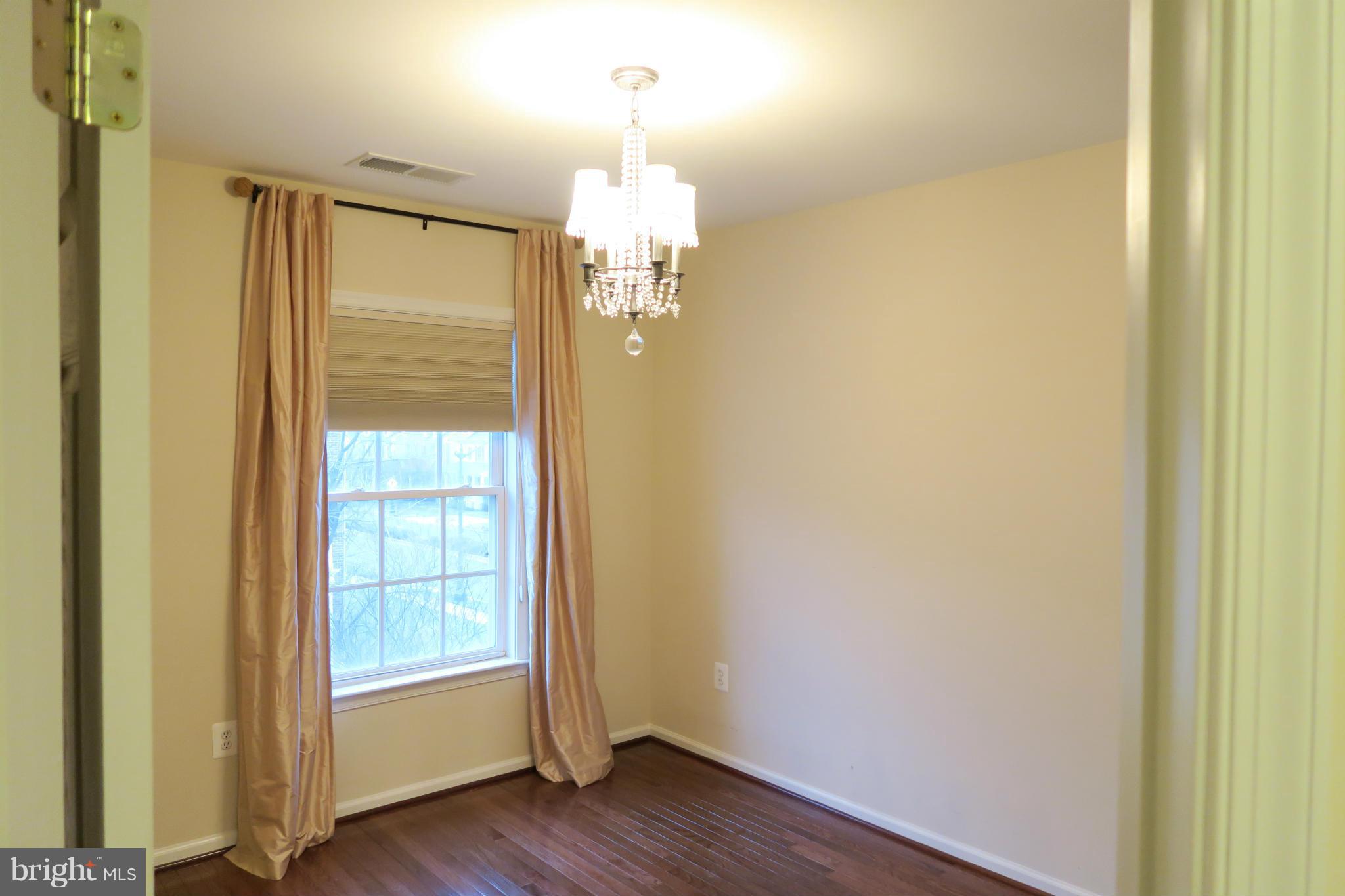 725 Ridgemont Avenue Rockville, MD 20850 - Photo 9 of 17 wooden floor in an empty room with a door