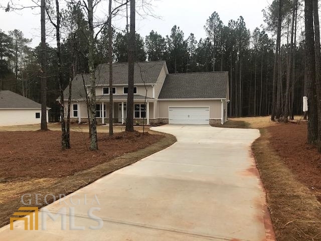a view of a house with backyard and trees