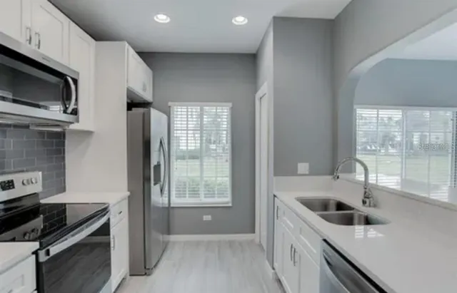 a kitchen with granite countertop a sink and a stove top oven