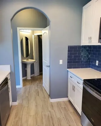 a kitchen with a refrigerator and wooden floor