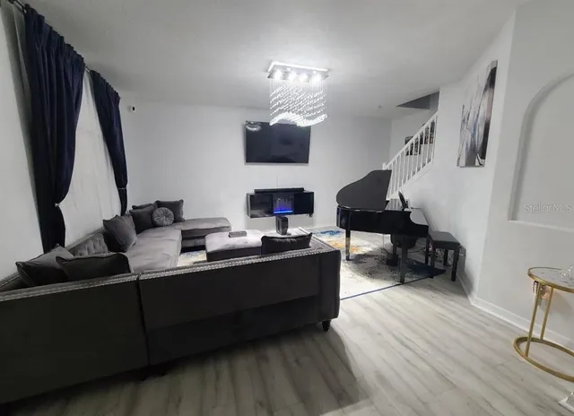 a living room with furniture and a wooden floor