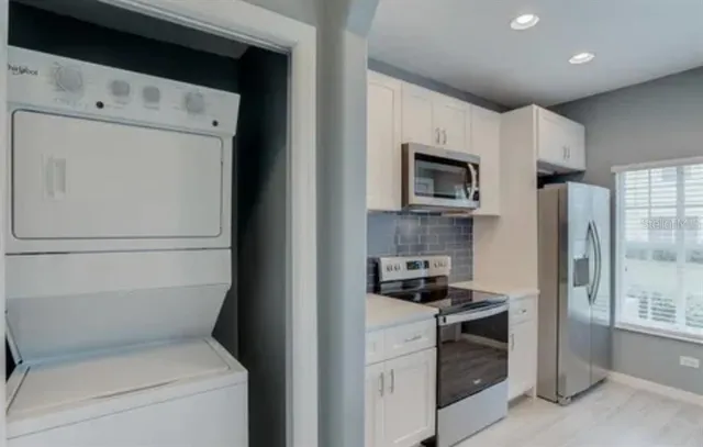 a kitchen with stainless steel appliances a refrigerator sink and stove
