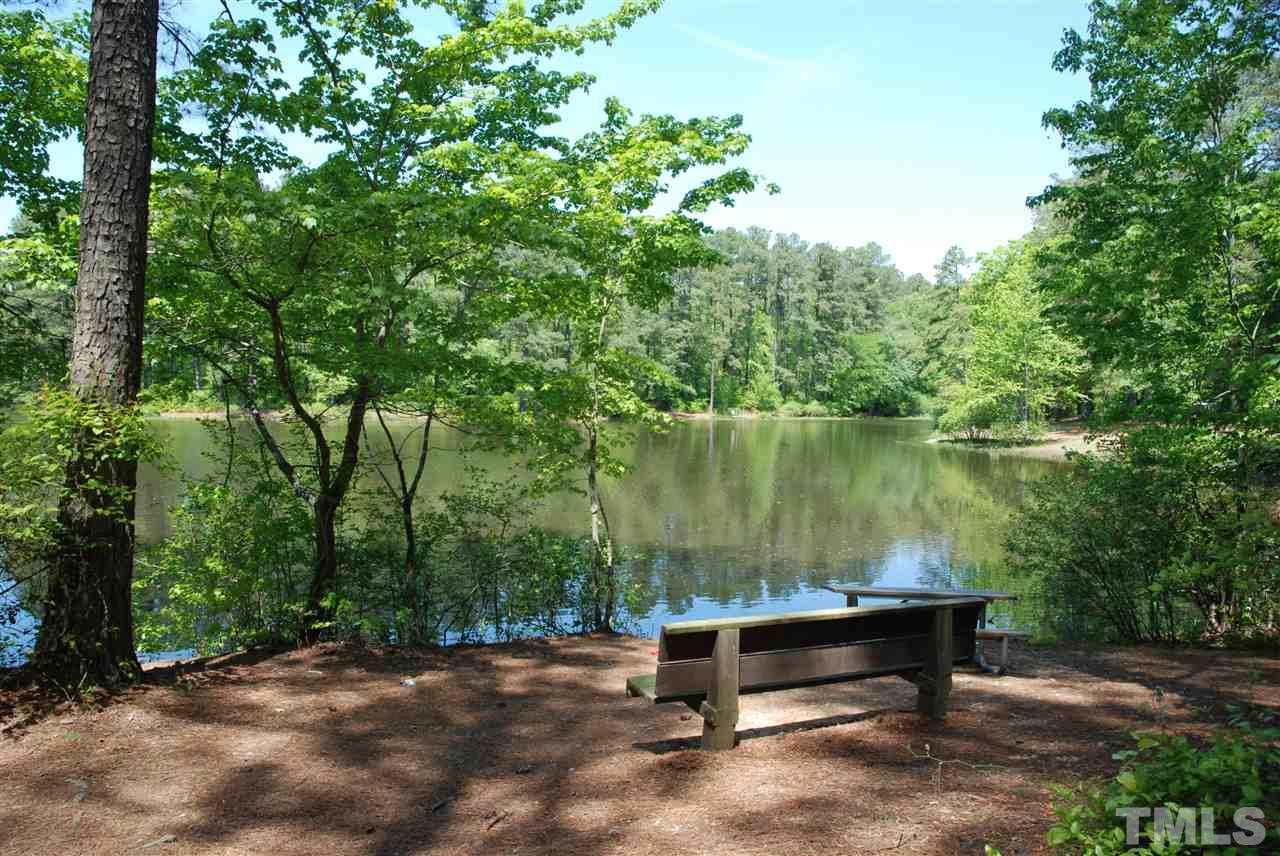 2232 Springhill Avenue Raleigh, NC 27603 - Photo 16 of 19 a wooden bench sitting next to a lake