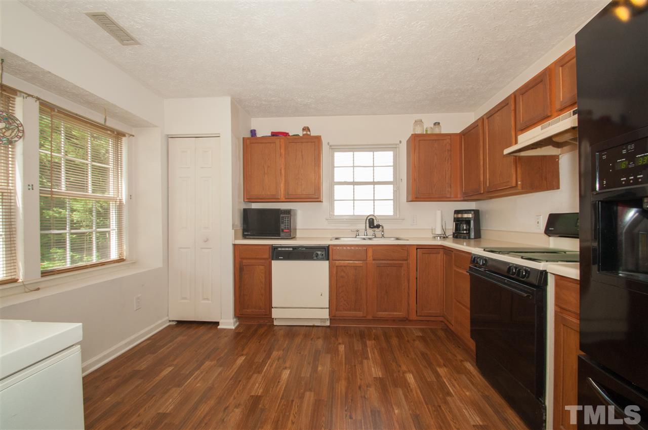 2232 Springhill Avenue Raleigh, NC 27603 - Photo 5 of 19 a kitchen with a sink wooden cabinets and a stove top oven