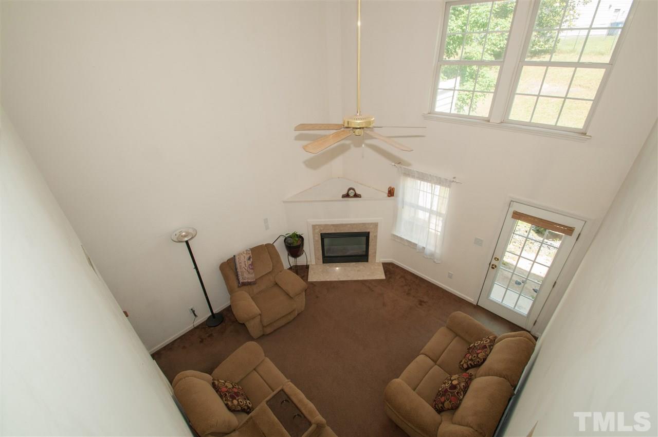 2232 Springhill Avenue Raleigh, NC 27603 - Photo 8 of 19 a living room with furniture a fireplace and a large window