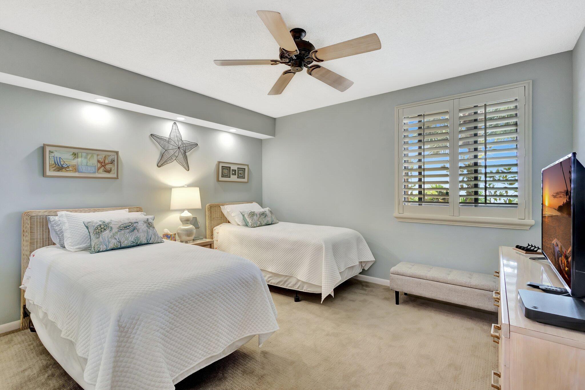 201 South Seas Drive, Unit 302 Jupiter, FL 33477 - Photo 13 of 19 a bedroom with two beds and a ceiling fan