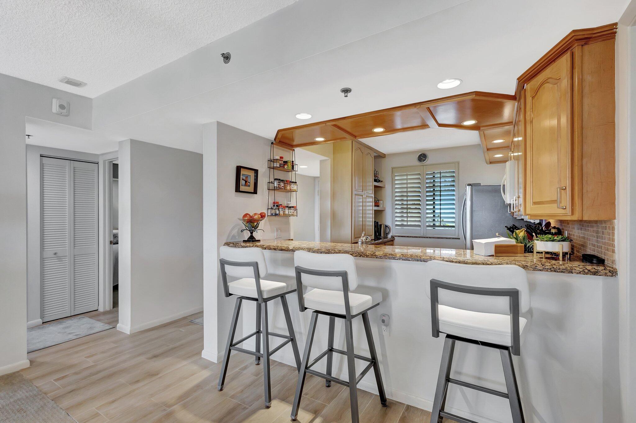 201 South Seas Drive, Unit 302 Jupiter, FL 33477 - Photo 15 of 19 a kitchen with sink and chairs