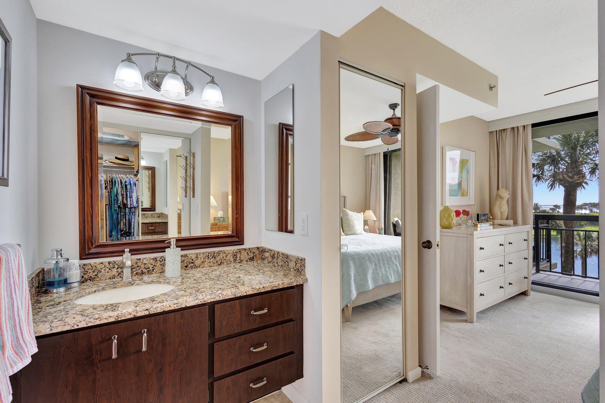 201 South Seas Drive, Unit 302 Jupiter, FL 33477 - Photo 18 of 19 a bathroom with double vanity sinks and a mirror
