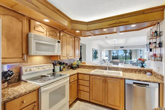 a dining room with furniture and view of kitchen