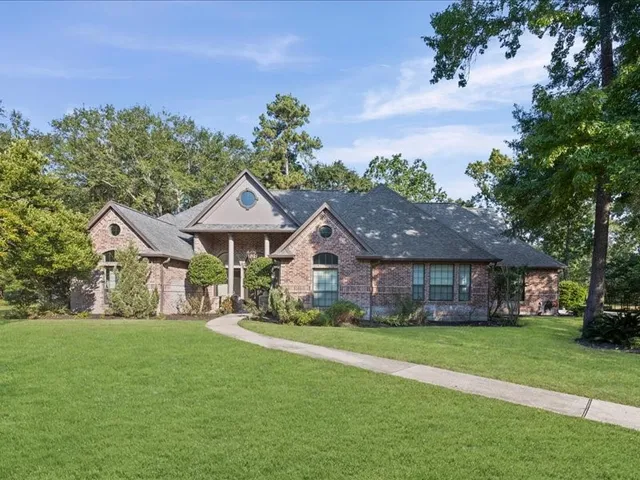 a front view of a house with a garden and trees