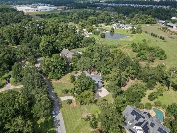 an aerial view of residential houses with outdoor space and trees