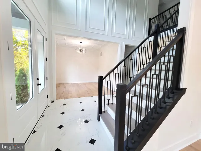 a view of staircase with lots of white furniture and a window