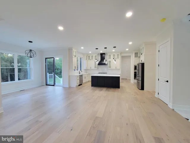 a view of a big room with wooden floor and windows