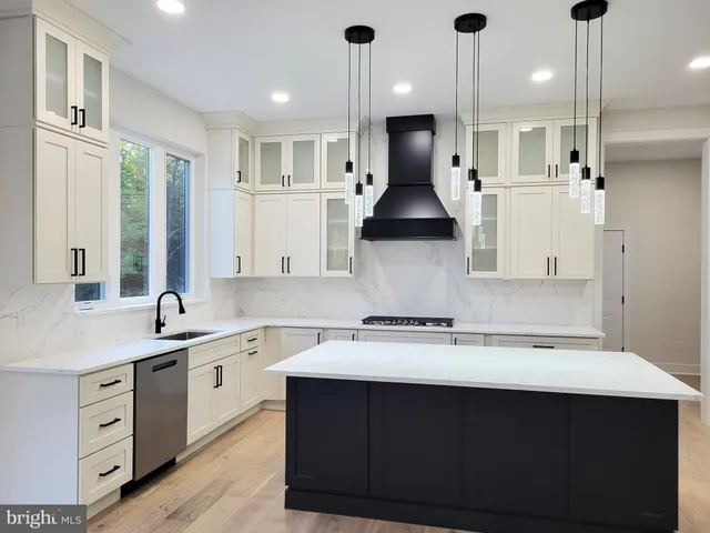 a kitchen with a sink a stove a refrigerator and white cabinets