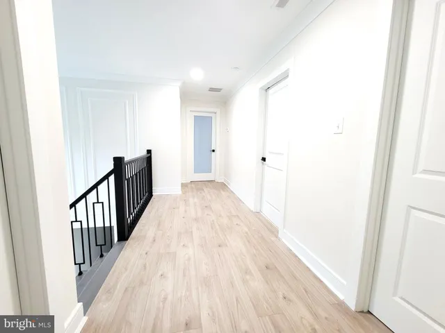 a view of a hallway with wooden floor