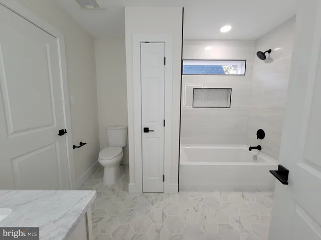a bathroom with a bathtub toilet and a shower