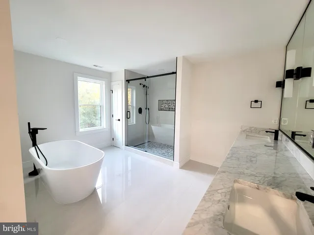 a large white tub sitting in a spacious bathroom
