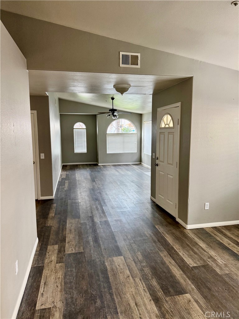 372 Via Capri Hemet, CA 92545 - Photo 6 of 27 a view of a hallway with wooden floor and a fireplace