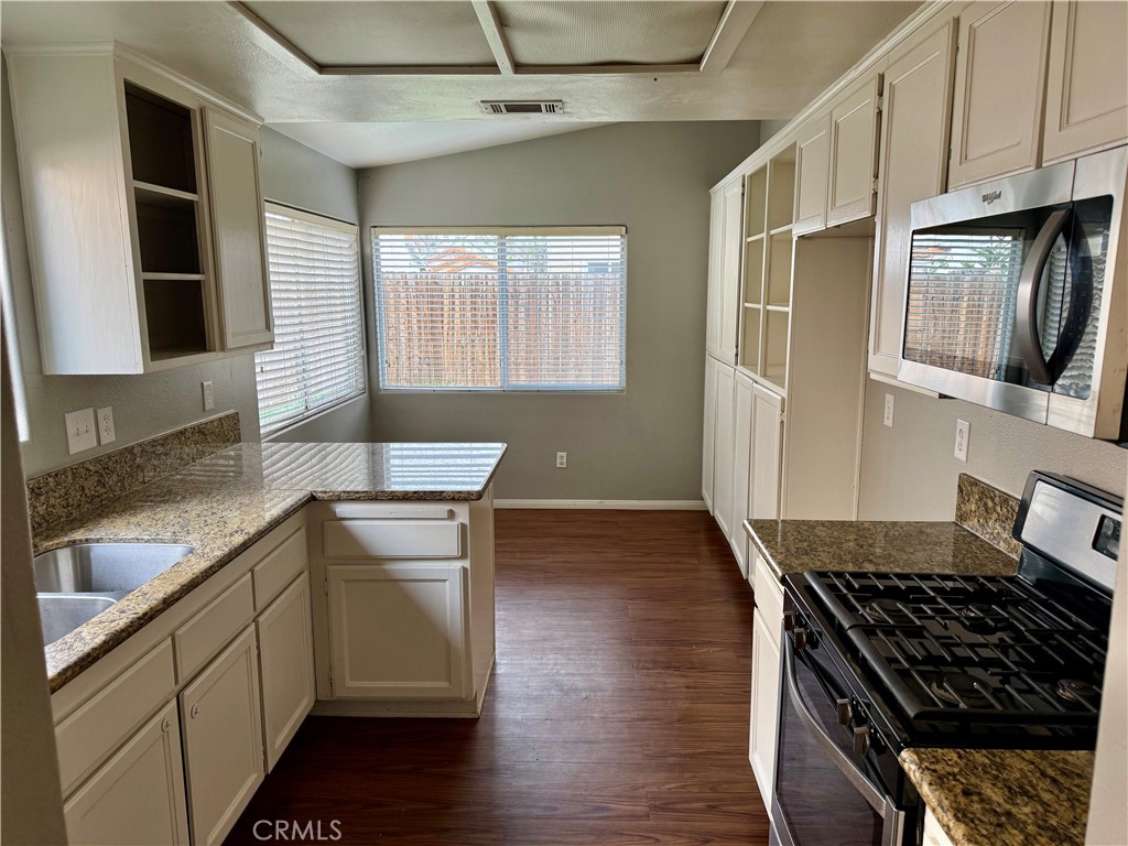 372 Via Capri Hemet, CA 92545 - Photo 9 of 27 a kitchen with granite countertop a stove and a sink