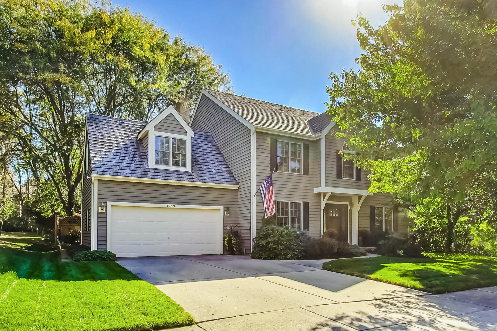 a front view of a house with a garden and yard